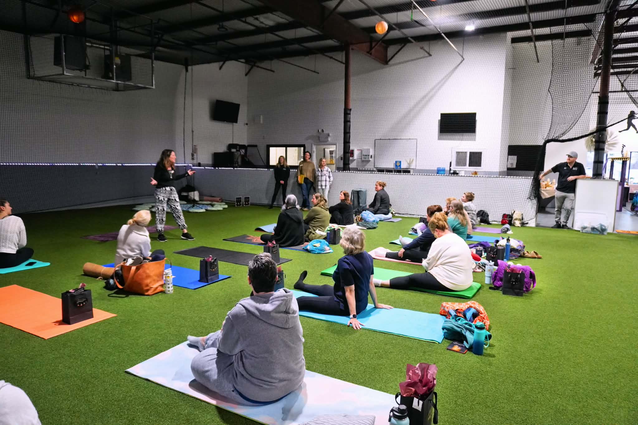 A group wellness class stretching on the indoor turf
